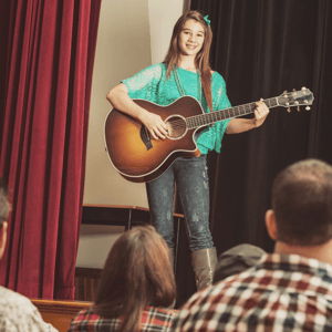 girl on stage with guitar